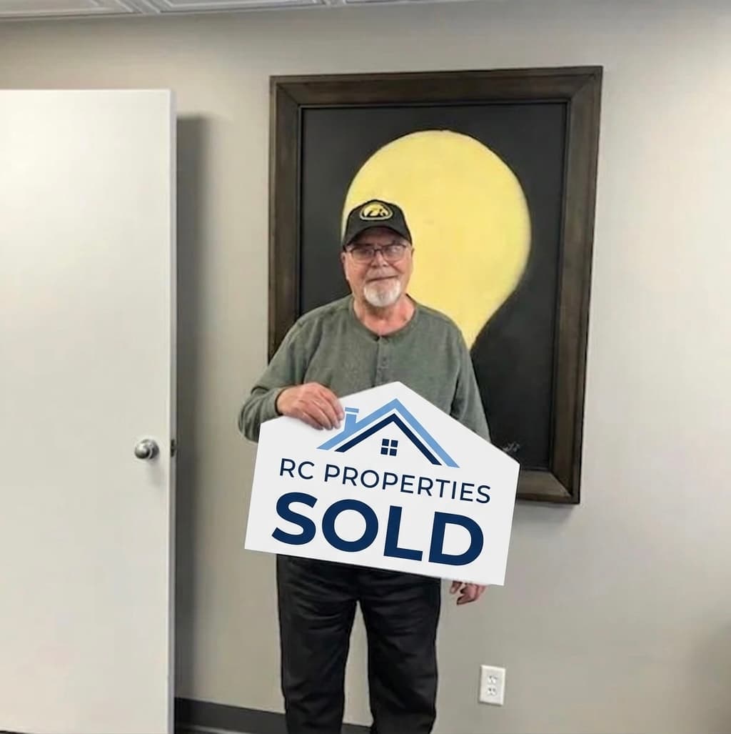 Happy RC Properties customer holding a sold sign
